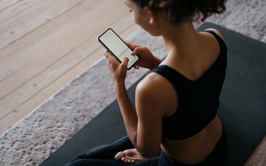 woman reading news before yoga